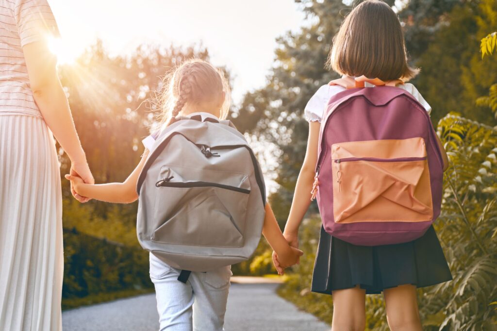 Bambini con zaino si avviano verso scuola